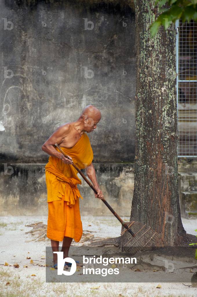 Thailand: Monk sweeping leaves, Wat Sao Thong, Nakhon Sri Thammarat