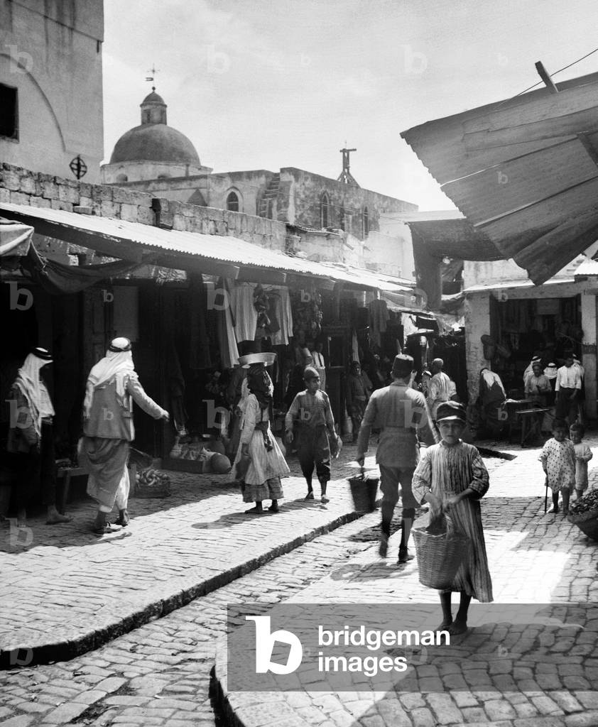 Palestine: The old bazaar at Nazareth with the dome of Mensa Christi Church, c. 1920