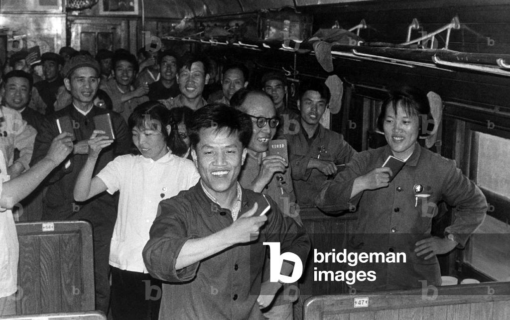 China: Scene from the Cultural Revolution (1966-1976), passengers on a train wave their copies of the 'Little Red Book' containing the selected thoughts of Chairman Mao Zedong (1967)