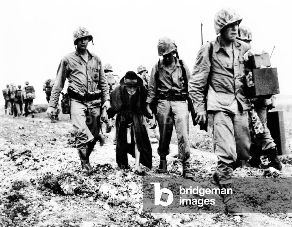 Japan / USA: US Marines help escort an elderly Okinawan civilian away from the front. Battle of Okinawa, May 1945 (photo)