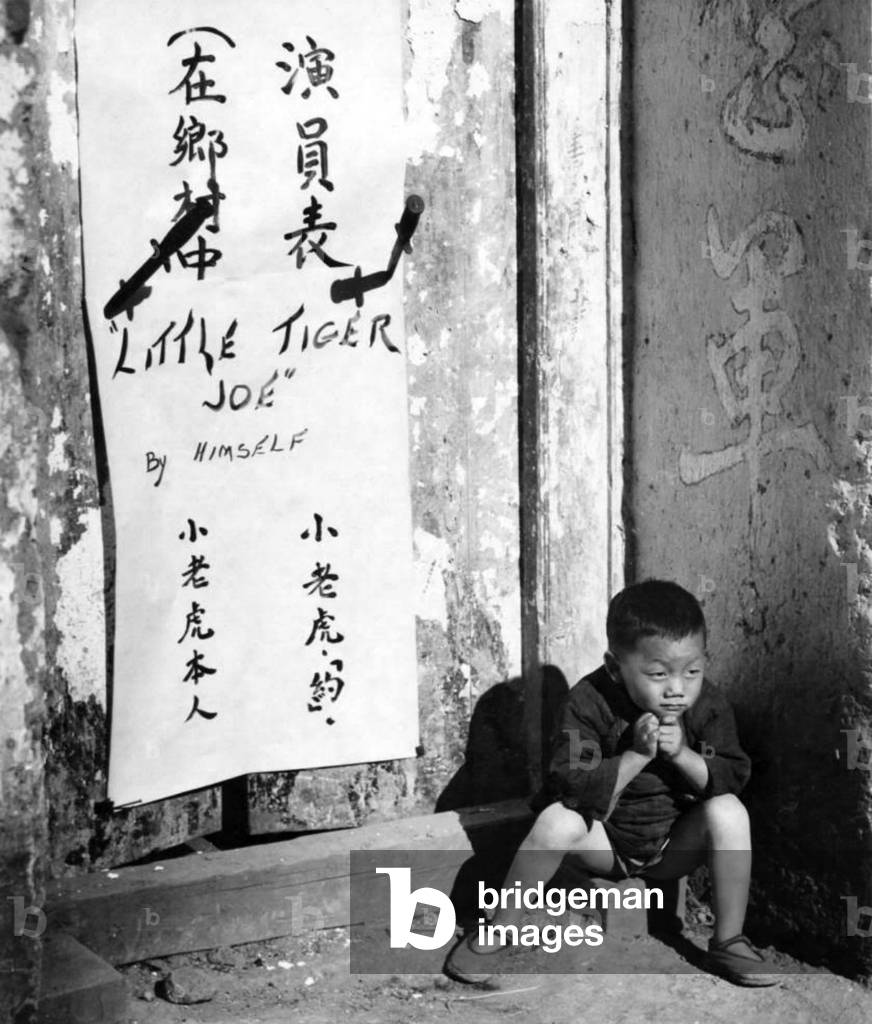 China: 'Little Tiger Joe', a three-year-old Chinese orphan informally adopted by the U.S. 907th Engineers Headquarters Company, Fourteenth Air Force ('The Flying Tigers'), Kunming, Yunnan Province, 30 November 1944 (photo)