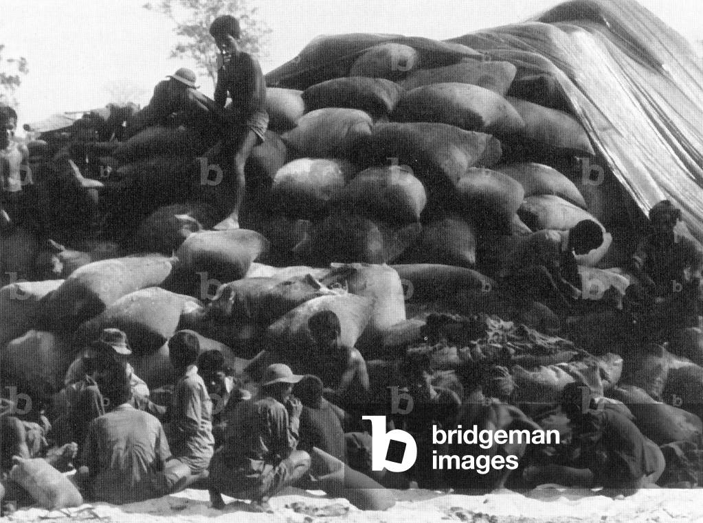 Cambodia: Cambodian workers piling up sacks of rice captured from communist forces during the 'Cambodian Incursion' of mid-1970.