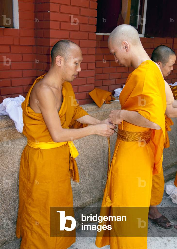 Thailand: Thai Buddhist ordination ceremony, Wat Rampoeng, Chiang Mai. The newly ordained monk is shown how to tie his first robe