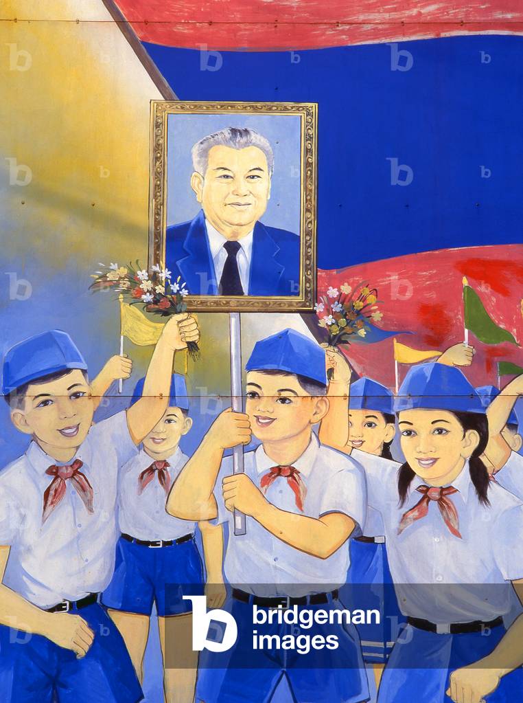 Laos: Children carry an image of Kaysone Phomvihane, President of Laos from 1991 until his death in 1992, Revolutionary Socialist realist-style political poster on the streets of Vientiane