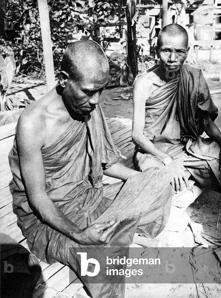 Burma/ Myanmar: A Buddhist monk in Burma reads a palm-leaf book, c.1920s.