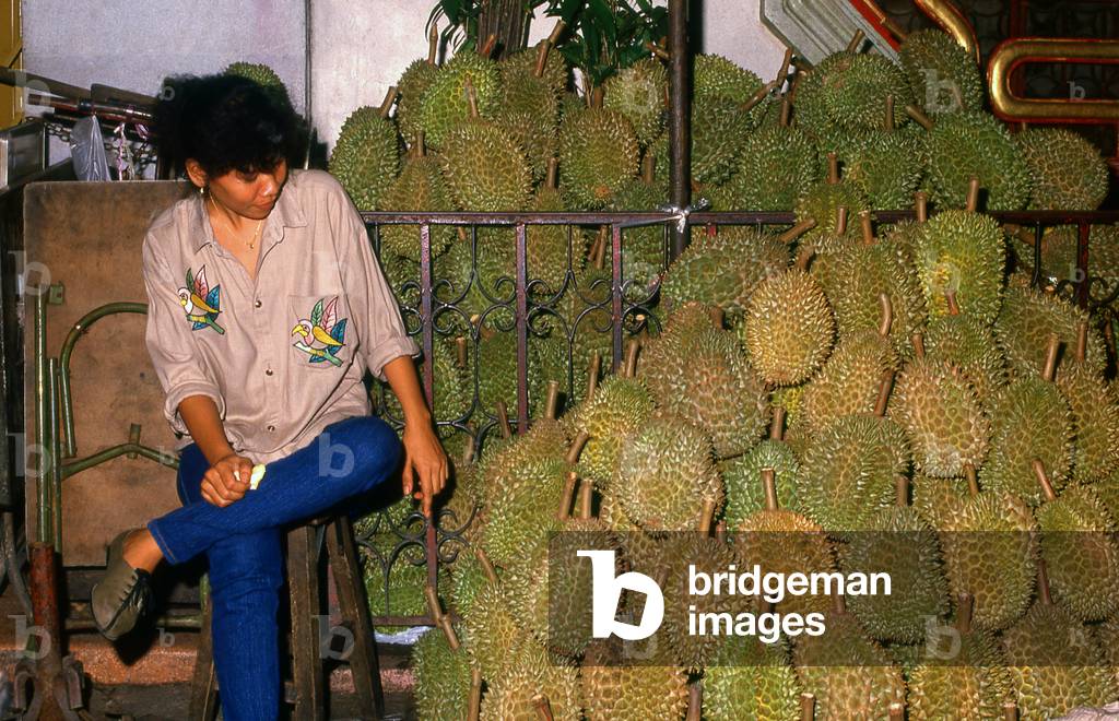 Thailand: A young durian vendor in a night market in Bangkok
