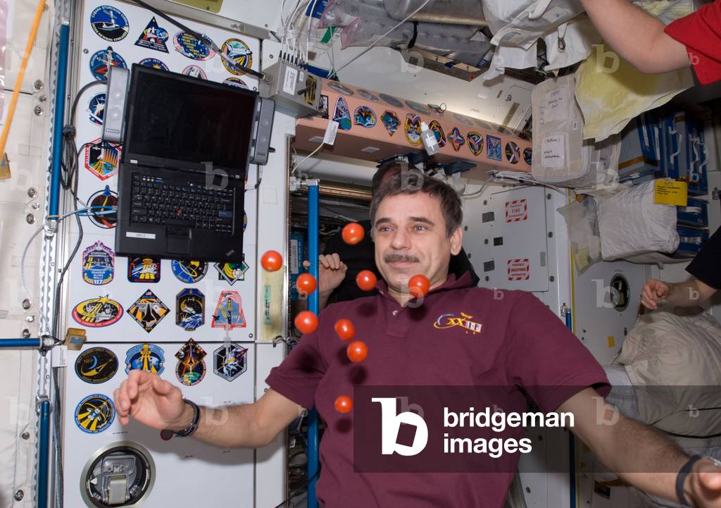 Astronaut in Weightless - Astronaut with fresh fruits - Cosmonaut Mikhail Kornienko has fun with tomatoes in the Unity module of the International Space Station (ISS). 16 May 2010. English cosmonaut Mikhail Kornienko, Expedition 23 flight engineer, is pictured near fresh tomatoes floating freely in the Unity node of the International Space Station while space shuttle Atlantis (STS - 132) remains docked with the station. 16 May 2010