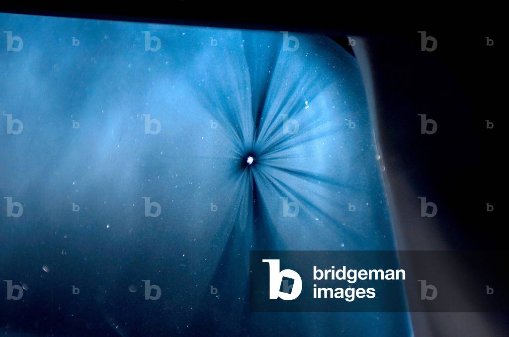 Impact on the window of the shuttle Endeavour - 03/2008 - Windows's impact crater on space shuttle Endeavour - 03/2008: Micro impact crater on one of the triple-glazed windows of the space shuttle Endeavour. March 2008. View of small ding on Space Shuttle Endeavours leftmost three-pane, 2.5-inch thick window (next to commanders seat) caused by micrometeorite impact. The ding is about 1/8th to 3/16th of an inch in diameter. NASA engineers evaluated the damage for reentry, and deemed it to be safe