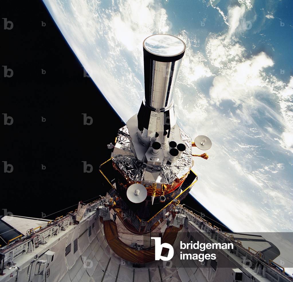 Military satellite DSP - Military satellite DSP tilted to predeployment position - Deploiement d'un satellite militaire DSP (Defense Support Program) on board the space shuttle Atlantis on 1 December 1991. These American spy satellites detect missile and spacecraft launches and nuclear explosions thanks to their infrared sensor that detects heat emissions. Defense Support Program (DSP)/Inertial Upper Stage (IUS) spacecraft, with forward airborne support equipment payload retention latch actuator released (foreground), is raised to a 29 degree predeployment position by the ASE aft frame tilt actuator (AFTA) table in the payload bay of Atlantis, Orbiter Vehicle 104. DSP components include Infrared sensor (top), AR I, SHF Antenna, EHF Antenna, Link 2 High - Gain Antenna, star sensor, and stowed solar paddles (box - like structure around the base). The Earth's limb and the blackness of space create the backdrop for this deployment scene. DSP satellites detect missile or spacecraft launches and nuclear explosions using sensors that detect the infrared emissions from these intense sources of heat