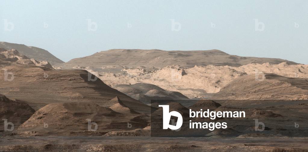 Mars surface seen by the rover Curiosity 09/2015 - Martian surface seen from the rover Curiosity 09/2015: Panorama of the surface of Mars on Mount Sharp. Mosaic of images obtained by the rover Curiosity on September 9, 2015. This composite image looking toward the higher regions of Mount Sharp was taken on September 9, 2015, by Nasa's Curiosity rover. In the foreground - about 2 miles (3 kilometers) from the rover - is a long ridge teeming with hematite, an iron oxide. Just beyond is an undulating plain rich in clay minerals. And just beyond that are a multitude of rounded buttes, all high in sulfate minerals. The changing mineralogy in these layers of Mount Sharp suggests a changing environment in early Mars, though all involve exposure to water billions of years ago. Further back in the image are striking, light-toned cliffs in rock that may have formed in drier times and now is heavily eroded by winds. The colors are adjusted so that rocks look approximately as they would if they were on Earth, to help geologists interpret the rocks. This “” white balancing”” to adjust for the lighting on Mars overly compensates for the absence of blue on Mars, making the sky appear light blue and sometimes giving dark, black rocks a blue cast