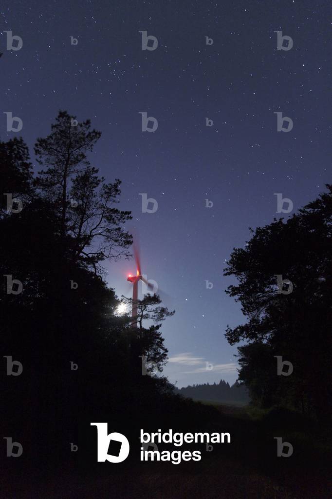 Star sky and wind turbine - Starry sky and wind turbine - A wind turbine is lit by a district of Moon. At the end of the way, the constellation of the Lion that heberge Saturn. June 10, 2008. A Quarter Moon is illuminating the hazy landscape. Brittany, France. June 10 2008