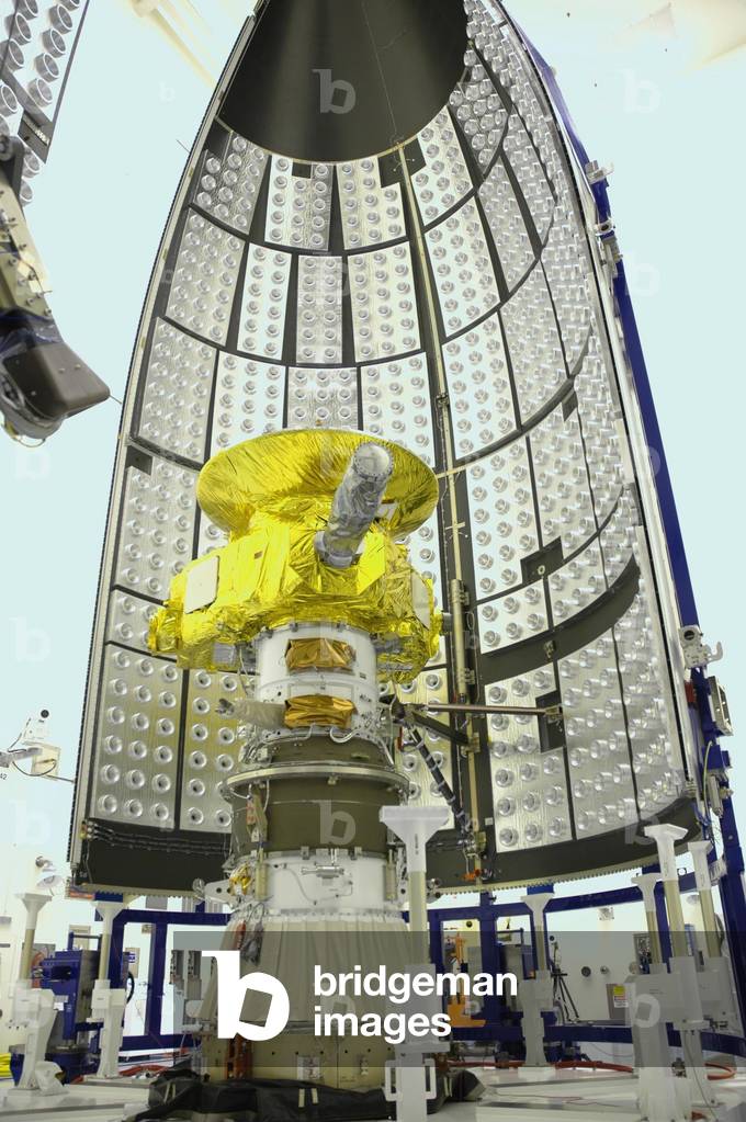The New Horizons probe - The New Horizons spacecraft - The New Horizons probe at Nasa's Kennedy Space Center in December 2005. The New Horizons probe was launched on 19 January 2006 to Jupiter, then Pluto and Charon, which it reached in 2015 and Kuiper's objects in 2020. In the Payload Hazardous Servicing Facility, the New Horizons spacecraft waits for encapsulation within the fairing sections waiting nearby. The fairing protects the spacecraft during launch and flight through the atmosphere. Once out of the atmosphere, the fairing is jettisoned. The compact 1,060 - pound New Horizons probe carries seven scientific instruments that will characterize the global geology and geomorphology of Pluto and its moon Charon, map their surface compositions and temperatures, and examine Pluto's complex atmosphere. After that, flybys of Kuiper Belt objects from even farther in the solar system may be undertaken in an extended mission. New Horizons is the first mission in Nasa's New Frontiers program of medium - class planetary missions. The spacecraft, designed for NASA by the Johns Hopkins University Applied Physics Laboratory in Laurel, Md., will fly by Pluto and Charon as early as summer 2015