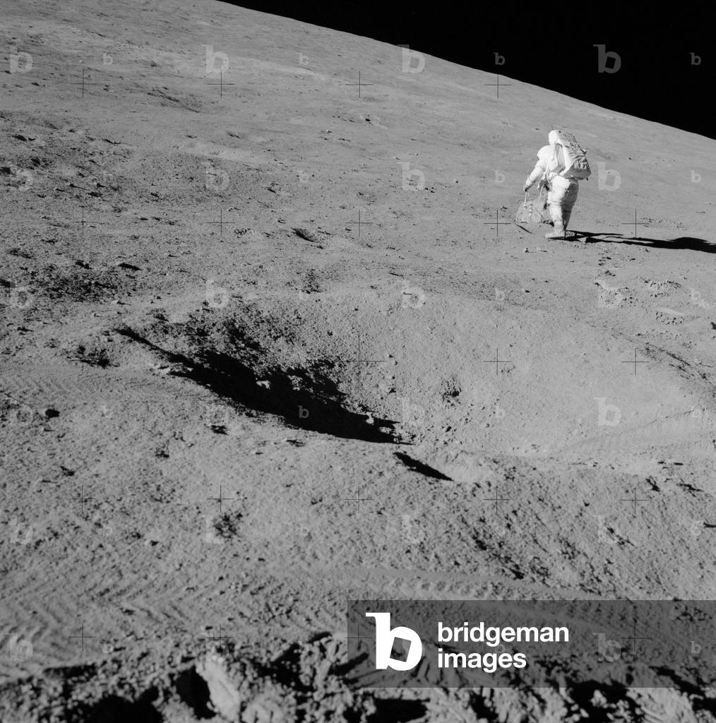 Apollo 15: D. Scott observes a rock - David Scott during Apollo 15 EVA - Extrahicular exit of David Scott on the slopes of Hadley Delta Astronaut David R. Scott, commander, studies a boulder on the slope of Hadley Delta during the Apollo 15 lunar landing mission's first extravehicular activity (EVA). He has both the gnomon and the flip-flops in his left hand