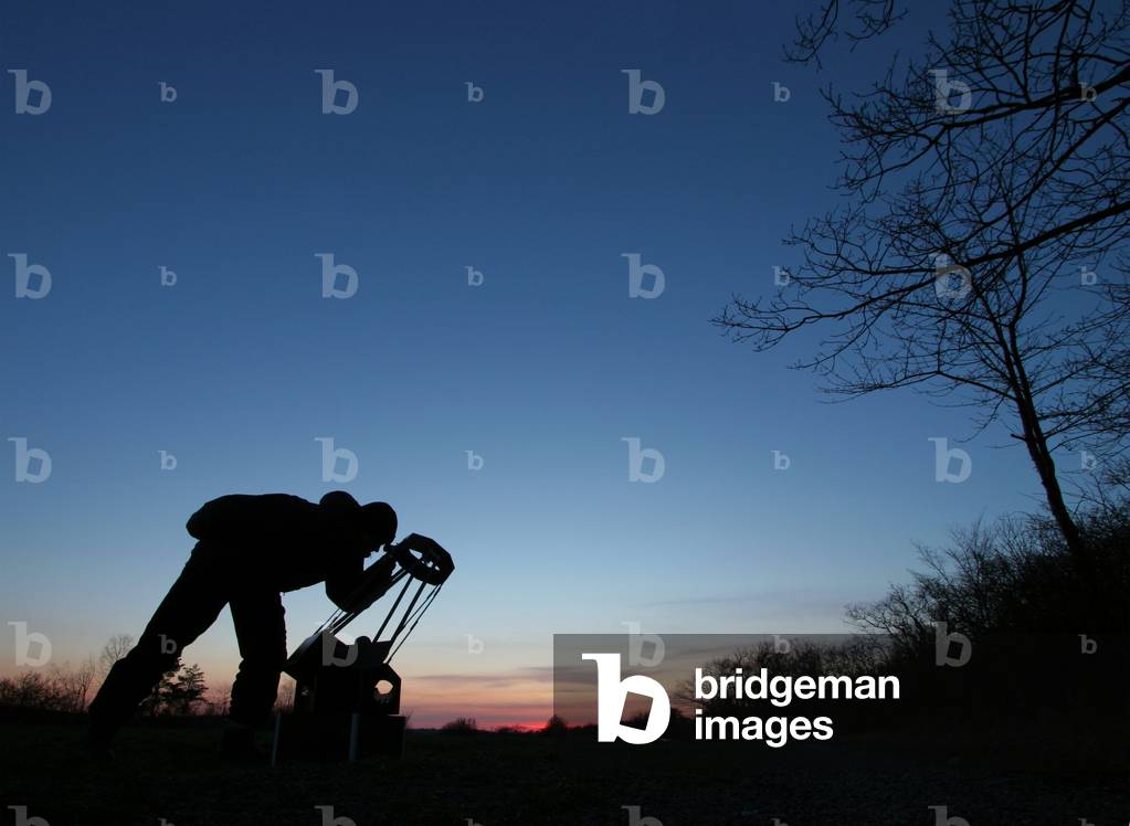 Night sky observation - Amateur astronomer observing the sky with a Dobson telescope. Amateur astronomer observing through a Dobsonian telescope