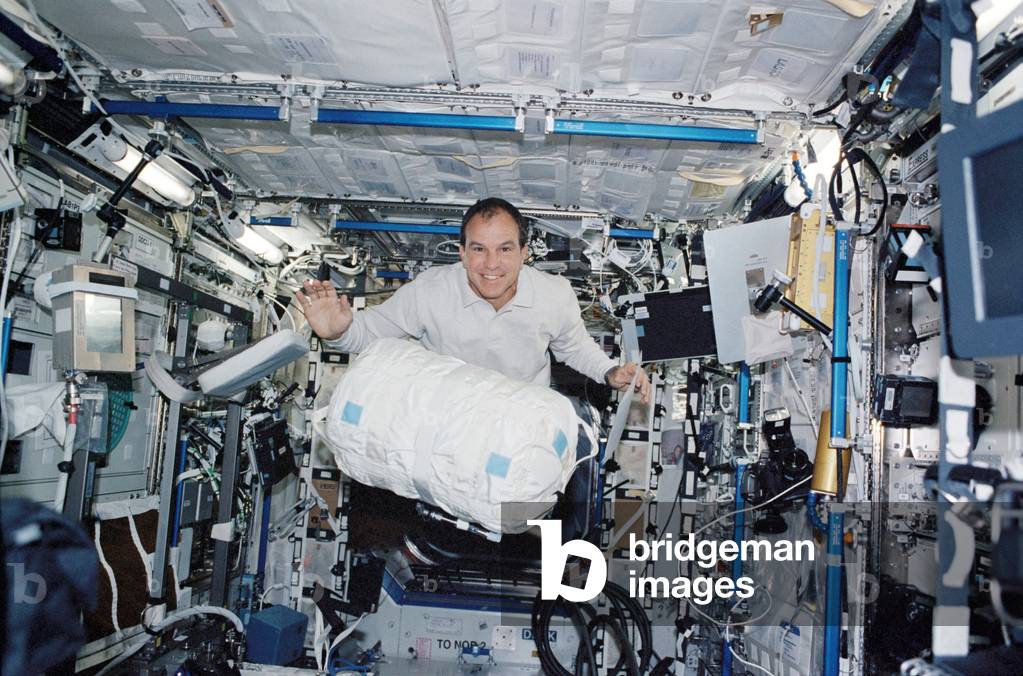 Astronaut in Destiny 04/02 - Michael Bloomfield is carrying a container of water into Destiny. ISS STS-110. April 2002