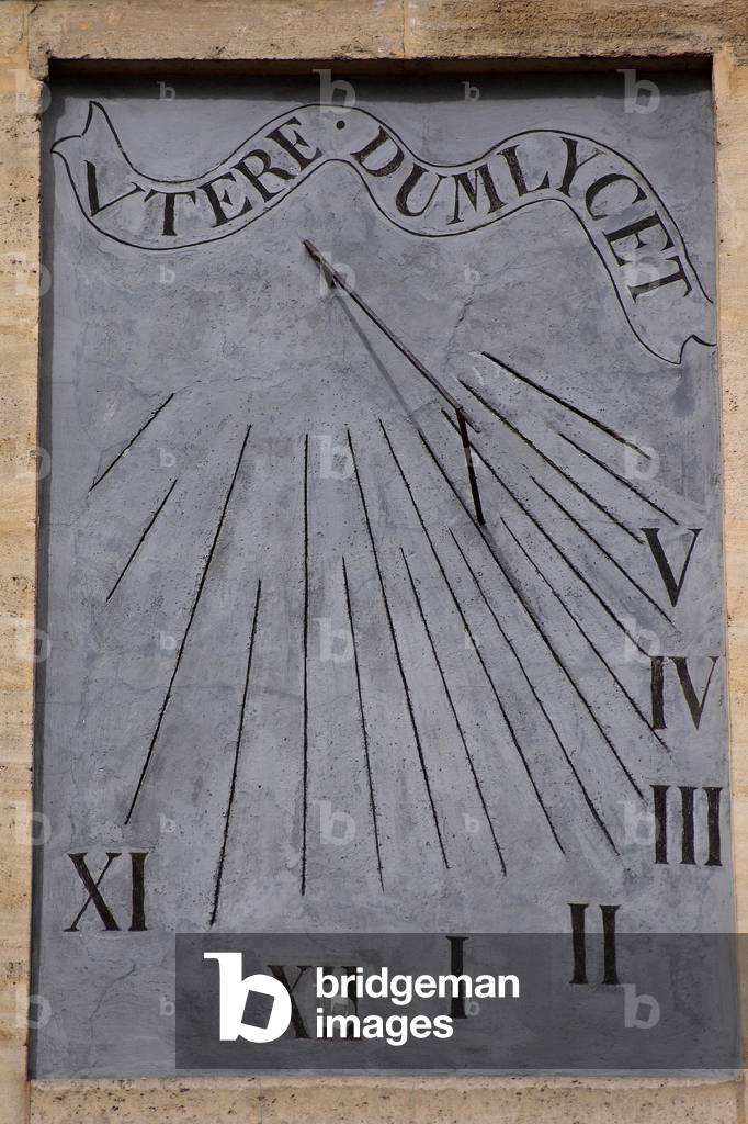 Sundial of the Convent de la Merci (Paris 3e) - Sundial in Paris: Sundial of the afternoon of the Convent de la Merci in the 3rd arrondissement of Paris. It indicates solar time from XI to V hours, with half hour indication. Painted on a grey background, it is surmounted by the Latin motto “Utere Dumlycet “” (enjoy, as long as possible). Sundial located in Convent de la Merci, Paris 3rd