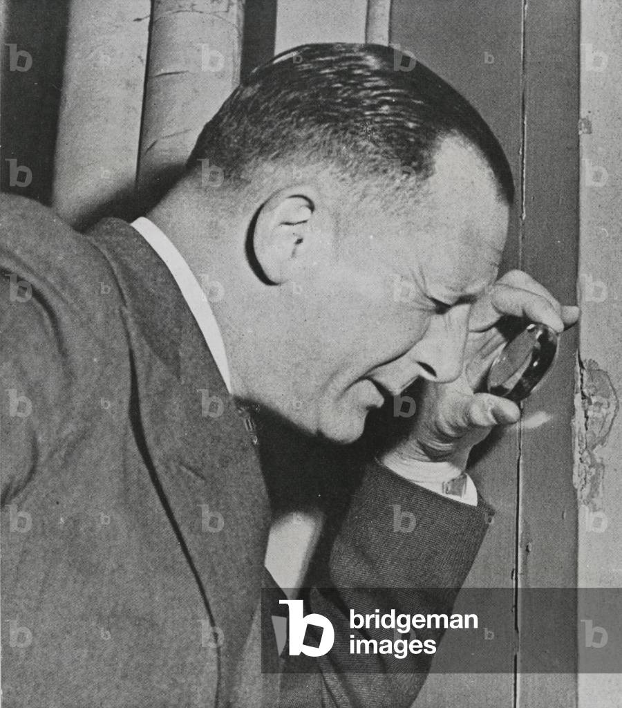 Detective Robert Fabian, the legendary 'Fabian of the Yard', examines the scene of a crime, 1946 (b/w photo)
