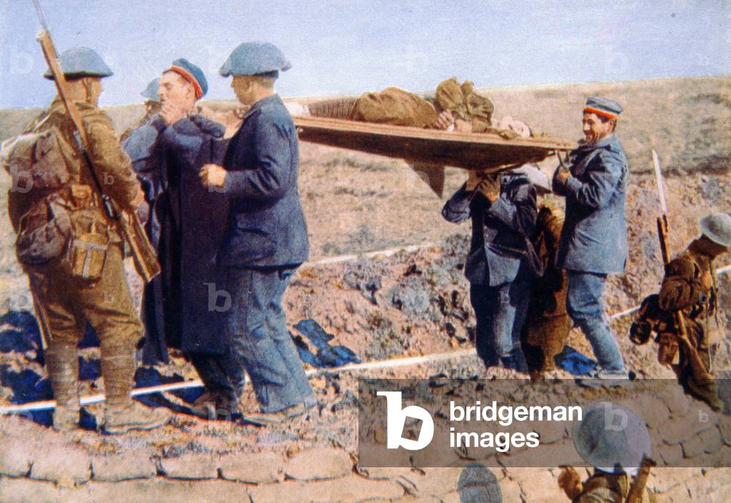 German prisoners help carry injured Canadian soldiers from front line trenches to a field hospital, 1914-18 (photo)