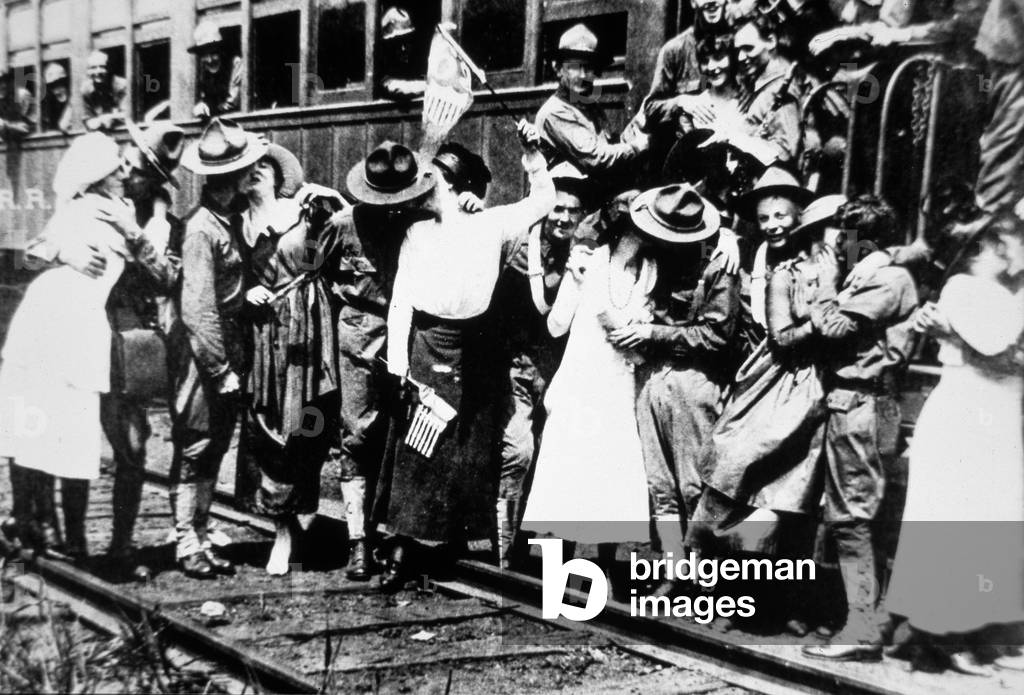 American soldiers of the 62nd Regiment kiss the girls goodbye as they leave for Europe, August 1917 (b/w photo)