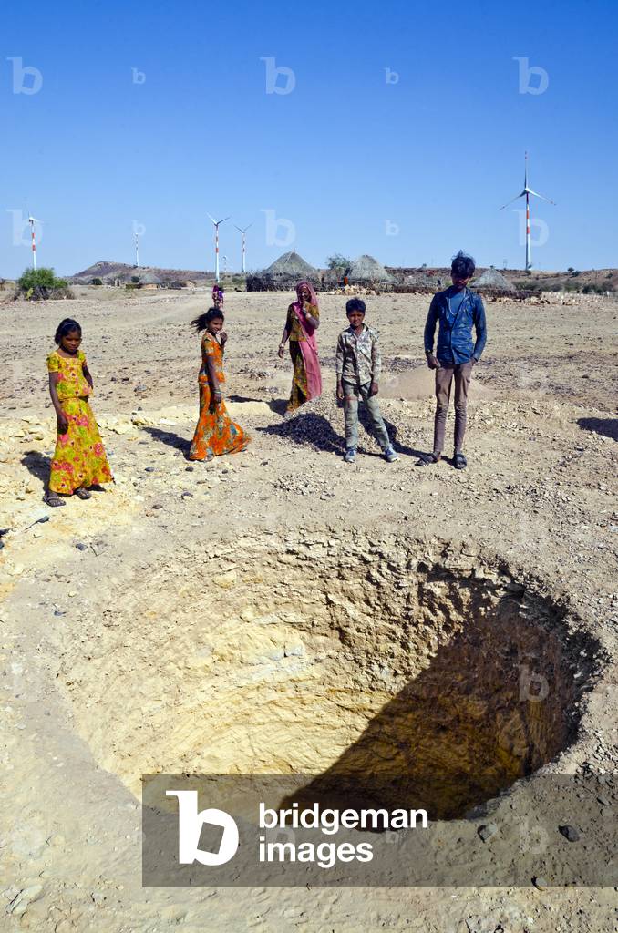 Thar Desert villagers (Jogi Nath Kalbelia tribe) around a newly dug hole to construct an underground drinking water storage tank for harvesting rainwater, Kodiyasar, Rajasthan, India (photo)
