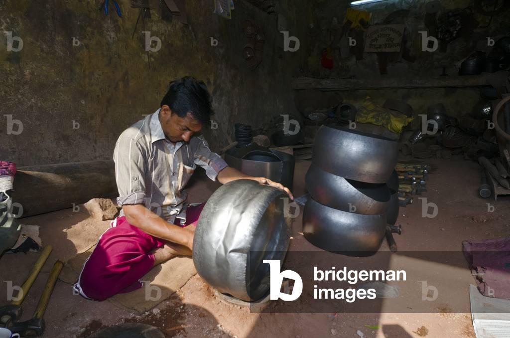 Man working in metal handicraft workshop sitting crosslegeed on ground,
Jodhpur, Rajasthan, India (photo)