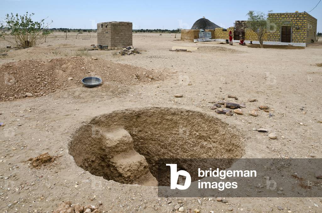 Hole to build a new rainwater harvesting underground drinking water storage tank in a desert hamlet, Thar Desert, Rajasthan, India (photo)