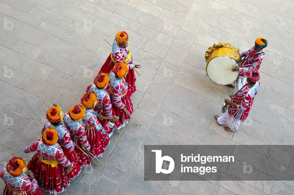 Gair dance: Orange-turbaned male tribal dancers from above, filing into courtyard at beginning of performance, accompanied by 2 drummers/percussionists,
Mehrangarh Fort, Jodhpur, Rajasthan, India (photo)