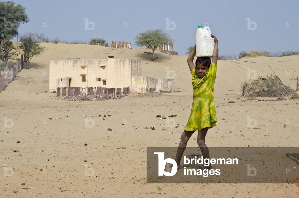 Indian girl carrying headload of water in plastic canister,
Keralha Bakhar, Rajasthan, India (photo)