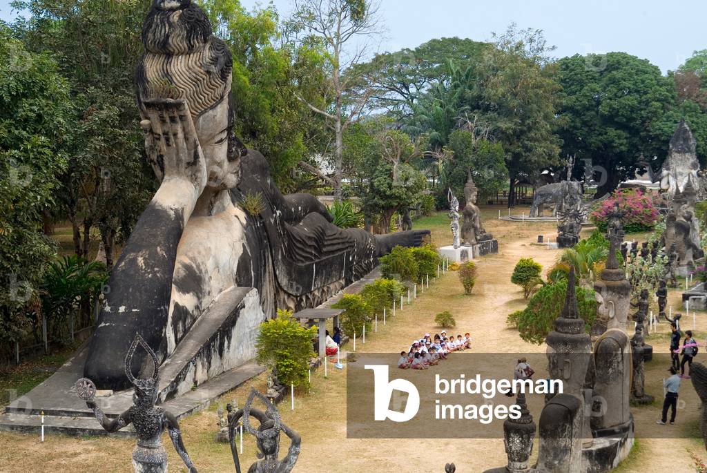 Primary school class posing for group photo in front of girant reclining Buddha statue (photo)