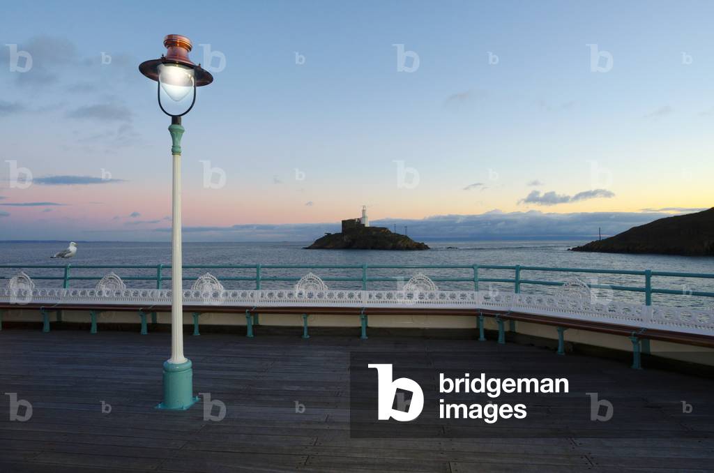 Victorian copper lamp illuminating pier, Mumbles Head, Pier and Lighthouse in sunset afterglow, Mumbles, Gower, South Wales, United Kingdom (photo)