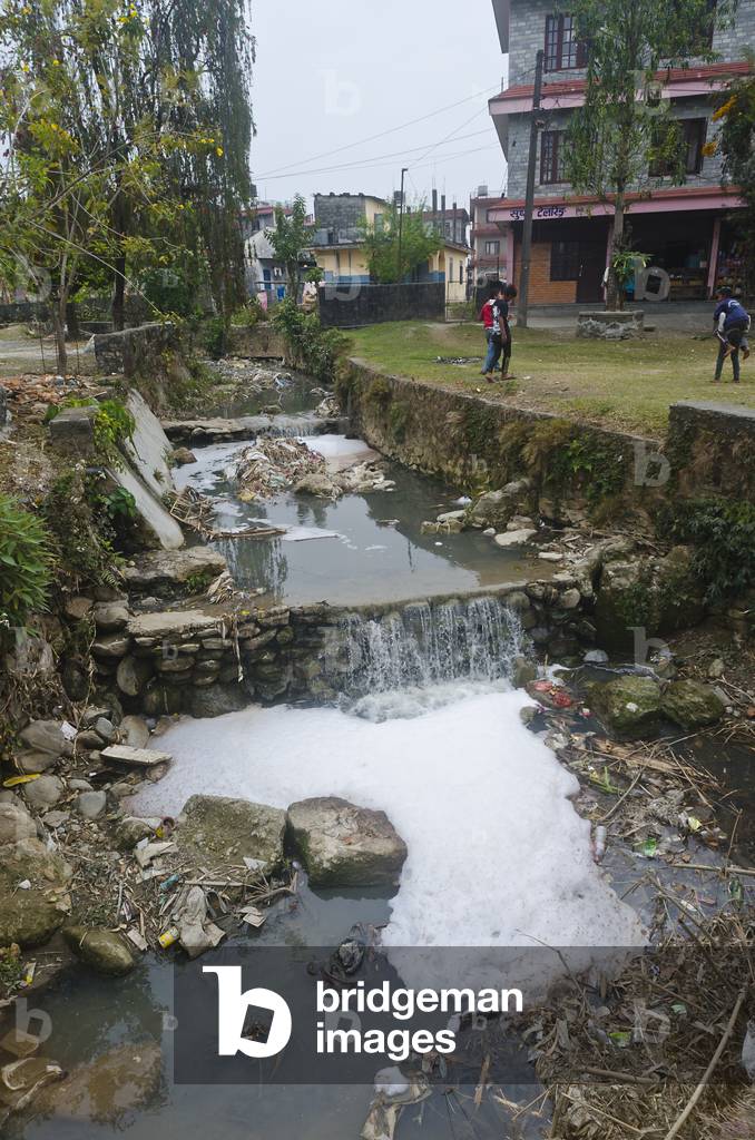 Polluted and rubbish-strewn stream running through residential city area, 
Pokhara, Nepal (photo)