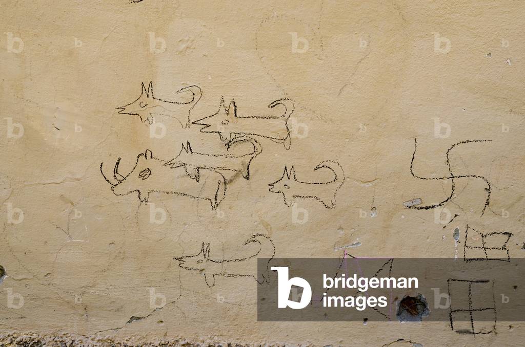 Graffiti showing a boar hunt &  swastika (Berber symbol for a bird) on house wall in High Atlas Berber mountain village, Tizgui, Mentaga Valley,  Taroudant Province,  Morocco (photo)