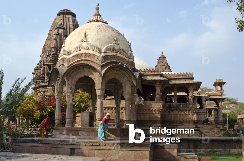 Mandore Gardens, Mandore: Elaborate sandstone chhatri, Indian women tidying,
Jodhpur, Rajasthan, India (photo)