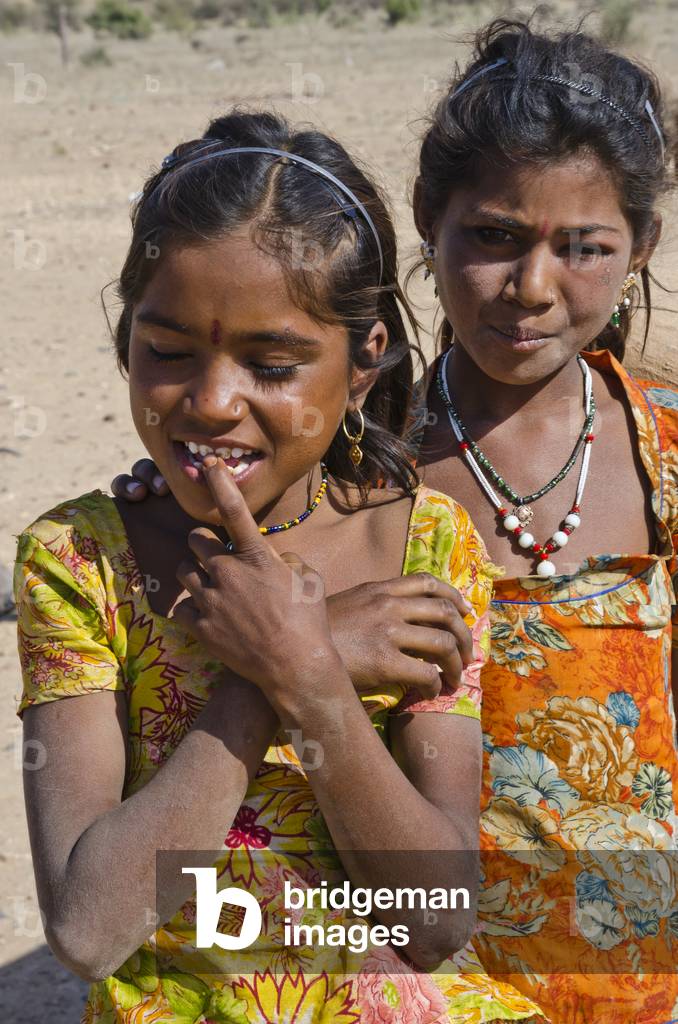 Two Rajasthani girls of the semi-nomadic Jogi Nath Kalbelia tribe in the Thar Desert settlement, Kodiyasar, Rajasthan, India (photo)