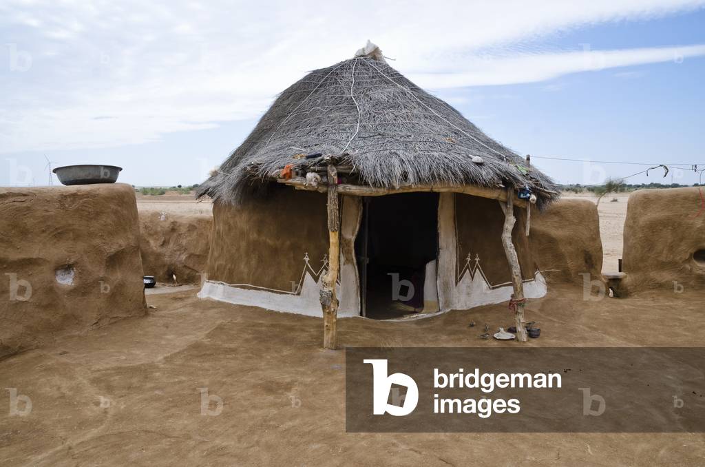 Traditional thatched and decorated earthen hut in a desert hamlet compound, Thar Desert, Rajasthan, India (photo)