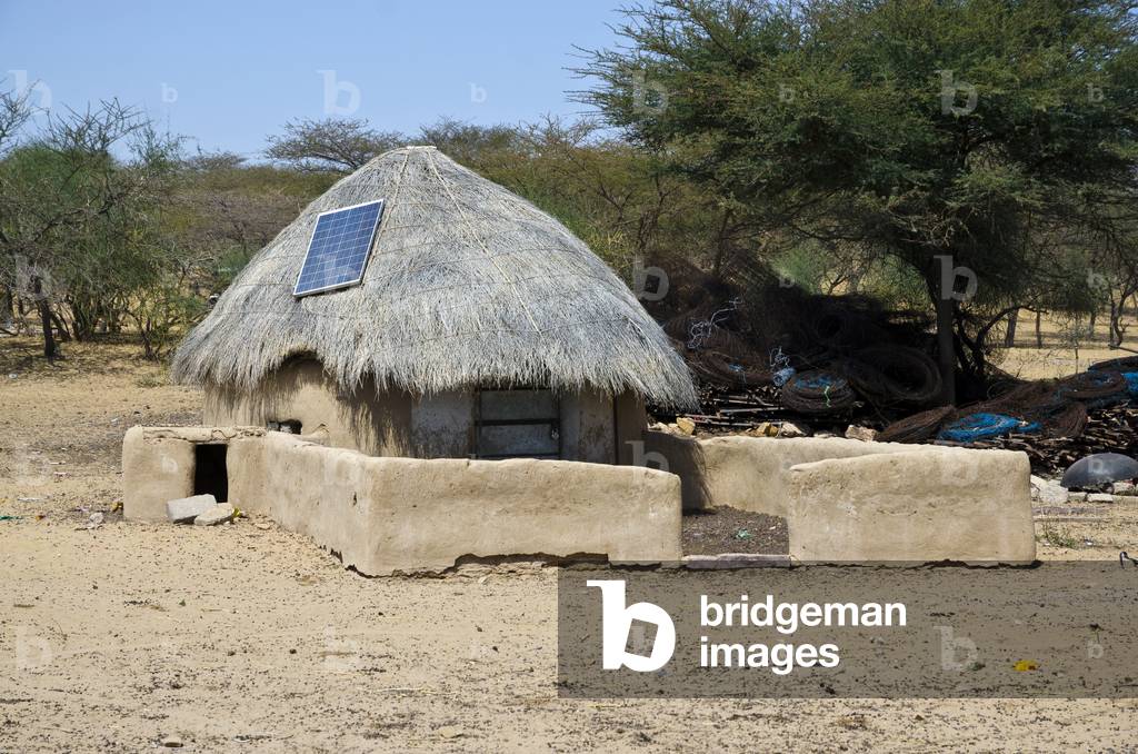PV Solar panel on a traditional thatched Thar Desert hut, Fatehgarh Tehsil, Rajasthan, India (photo)