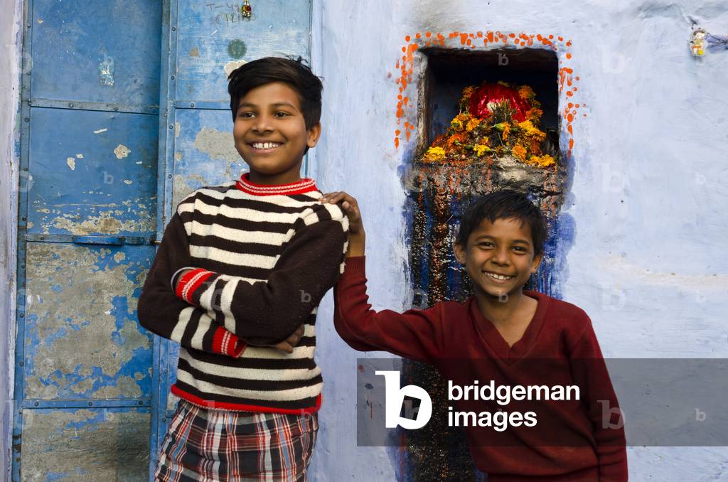 Two smiling Indian boys in front of simple Hindu shrine,
The Old Blue City, Jodhpur, Rajasthan, India (photo)