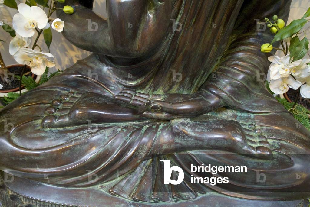 Feet of Buddha sculpture in full lotus position, left hand mudra symbolizing meditation, Harnham Buddhist Monastery, Northumberland, UK (photo)