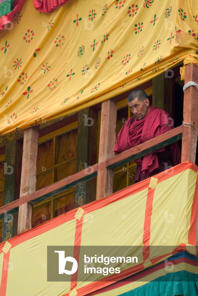 A monk watching the dances from a decorated wooden balcony, annual Tshechu festival, Hemis Monastery, Ladakh (photo)