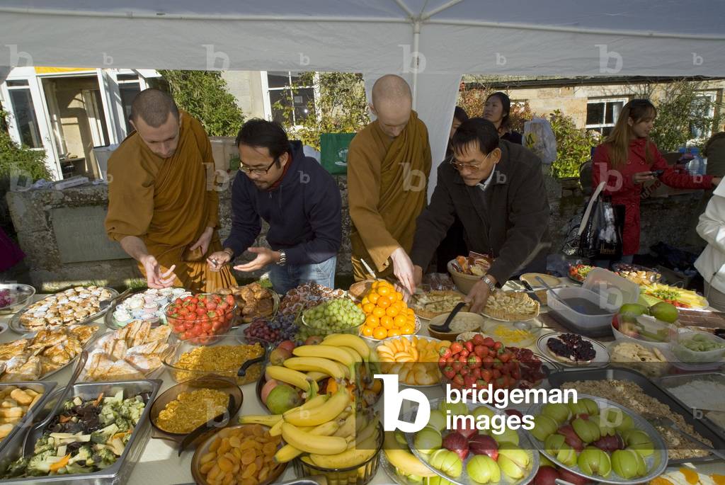 Lay supporters offering food to the monastic community during Kathina celebration, Harnham Buddhist Monastery, Northumberland, UK (photo)