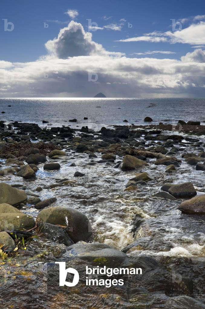 Peaty stream on rugged beach running through the intertidal zone into the sea, Kildonan Shore, Isle of Arran, North Ayrshire, Scotland, UK (photo)