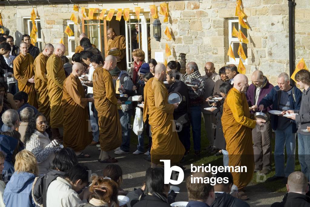 Lay supporters making rice offering to the monastic community during Kathina celebration, Harnham Buddhist Monastery, Northumberland, UK (photo)