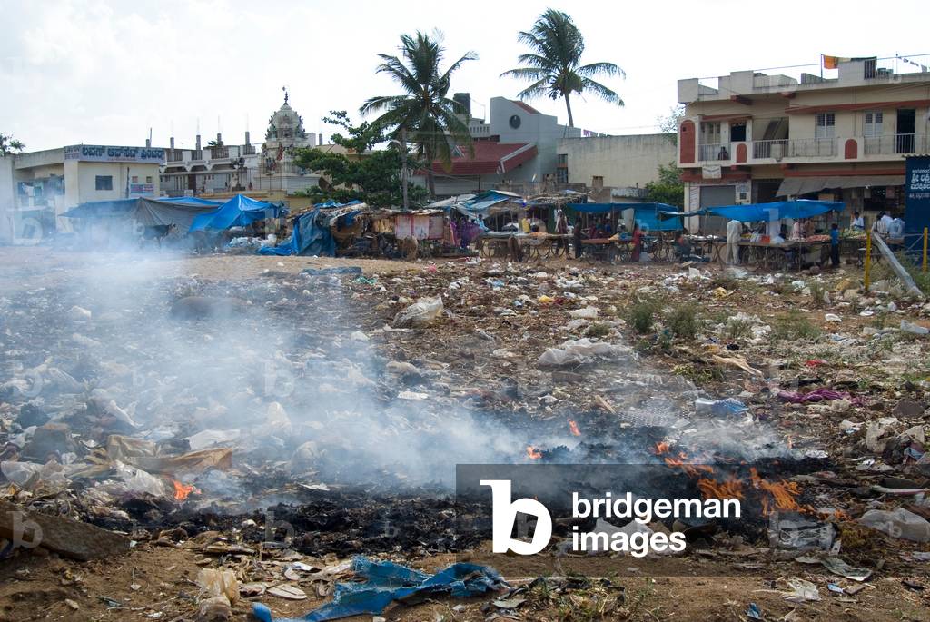 Burning rubbish on wasteground next to houses in Sunkadakatte, Bangalore, Karnataka, India