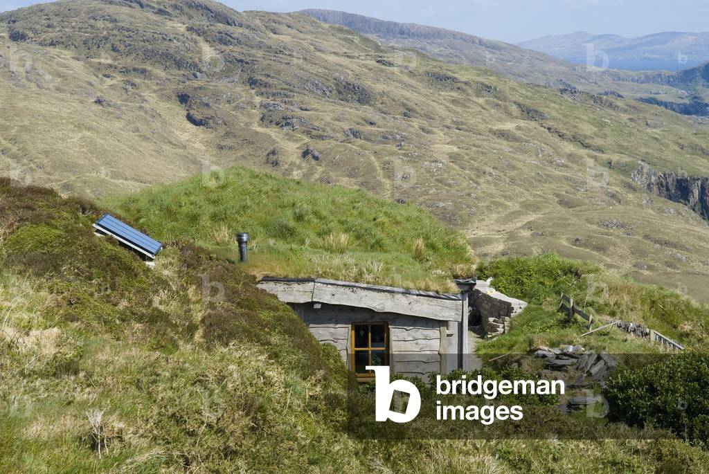 Low-impact building: Grass-roofed house with photovoltaic solar panel blended into mountainside, Beara Peninsula, West Cork, Republic of Ireland (photo)