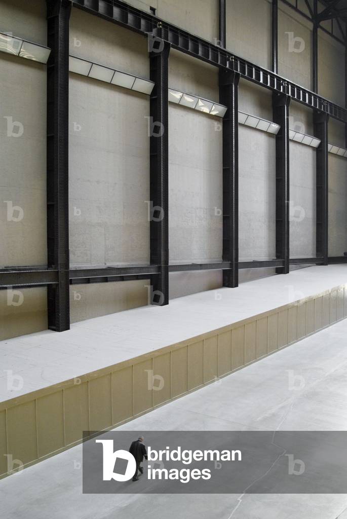 Man walking dwarfed by huge steel-girdered empty hall, Turbine Hall, Tate Modern, London, UK (photo)
