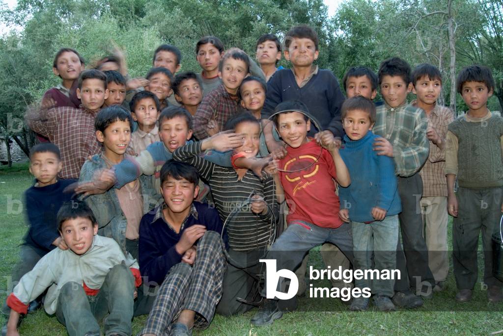 Group of Ladakhi children jostling and posing for picture at Snow Leopard Conservancy (SLC) camp at dusk,
Lower Suru Valley, Western Ladakh, India (photo)