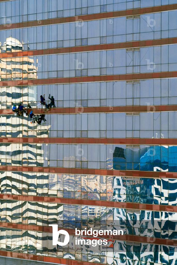 Four window cleaners suspended on facade of skyscraper (Sofitel Silom Hotel), city reflections, 
Silom Road, Bang Rak District, Bangkok, Thailand (photo)