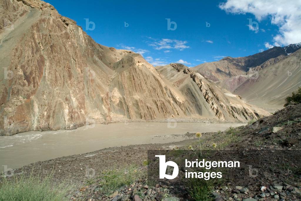 Indus river running alongside steep mountain flank in eroding valley, sediment, Alchi, Ladakh, Himalayas, Jammu and Kashmir, India (photo)