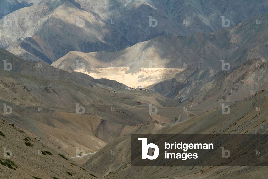 Himalayan landscape: Lamayuru Gompa (monastery) from Fatu La Pass (4094m), truck on mountain road Ladakh, Jammu and Kashmir, India (photo)