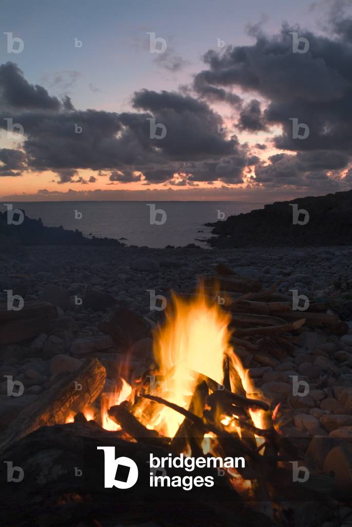 Bonfire on beach in sunset afterglow, Ramsgrove, South Wales (photo)